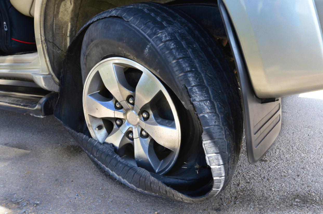 Tire blowout, auto repair in Sterling Heights, MI at Gordie's Auto & Tire. Image of a severely damaged and shredded SUV tire requiring professional tire replacement for safe driving.